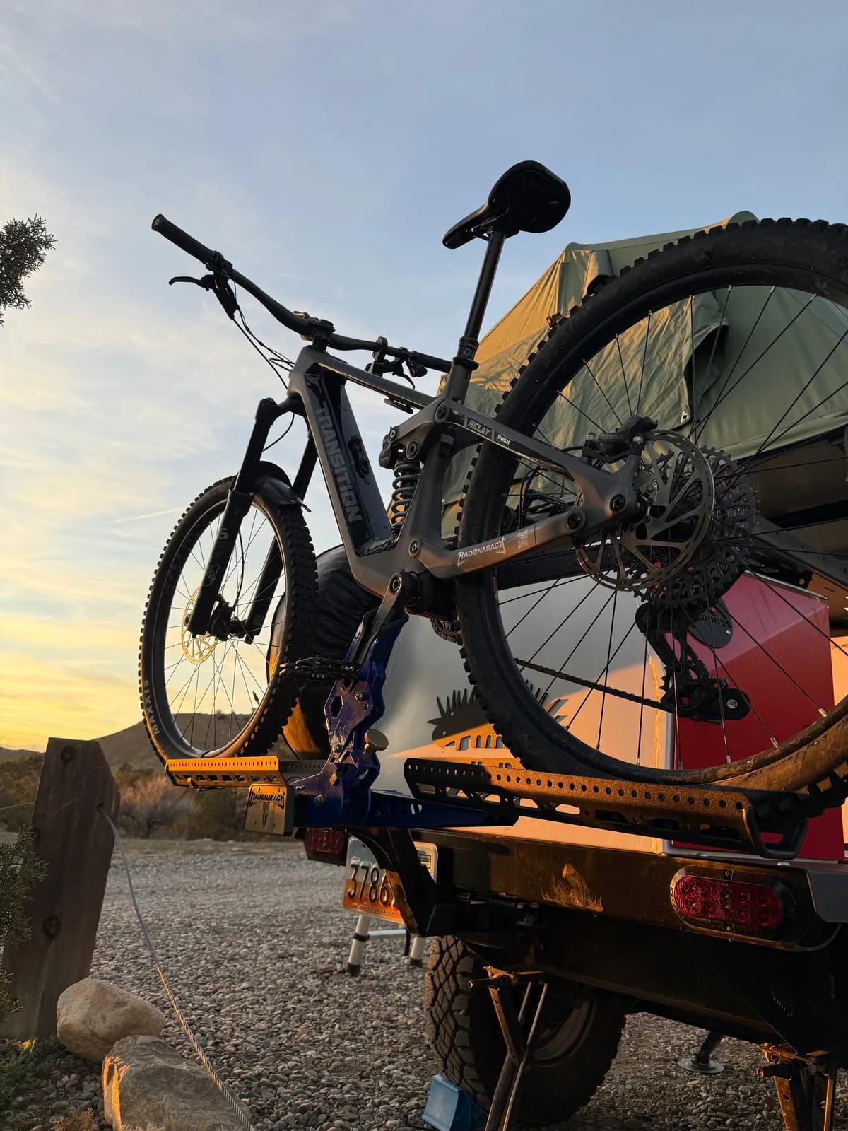 Transition mountain bike on a custom blue RadGnaRack hitch rack at sunset
