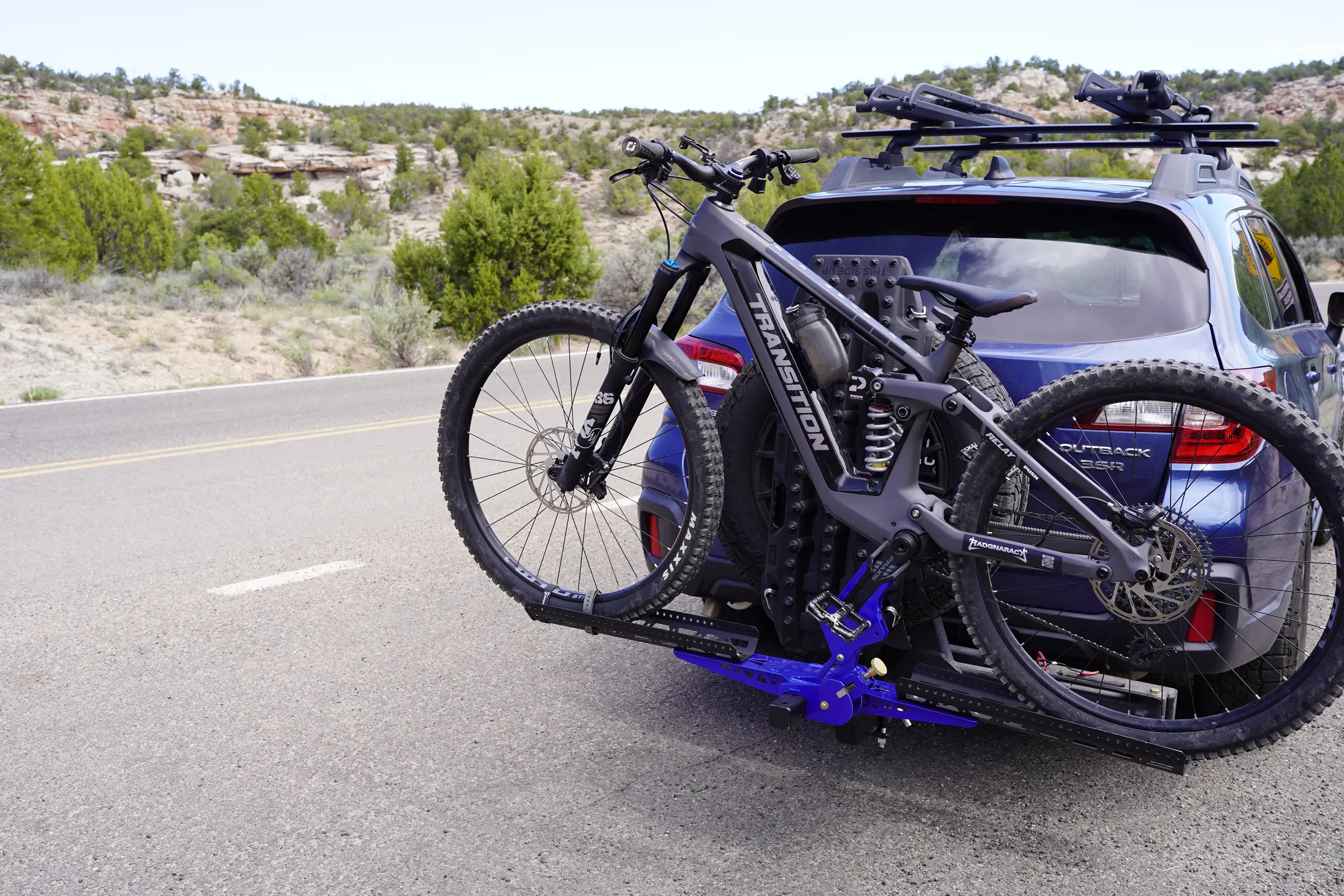 Blue Subaru with a loaded RadGnaRack on a Utah high-desert road